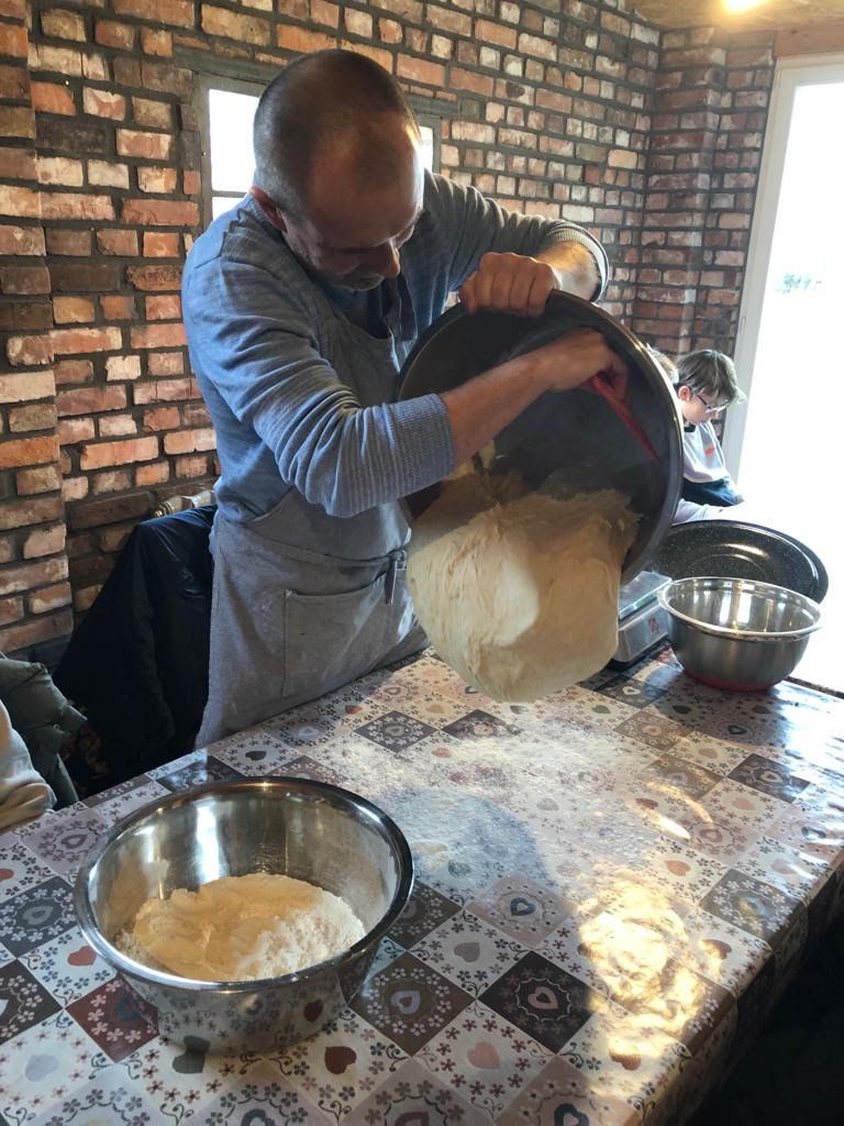 Warsztaty kulinarne - prowadzący zajęcia piecze chleb