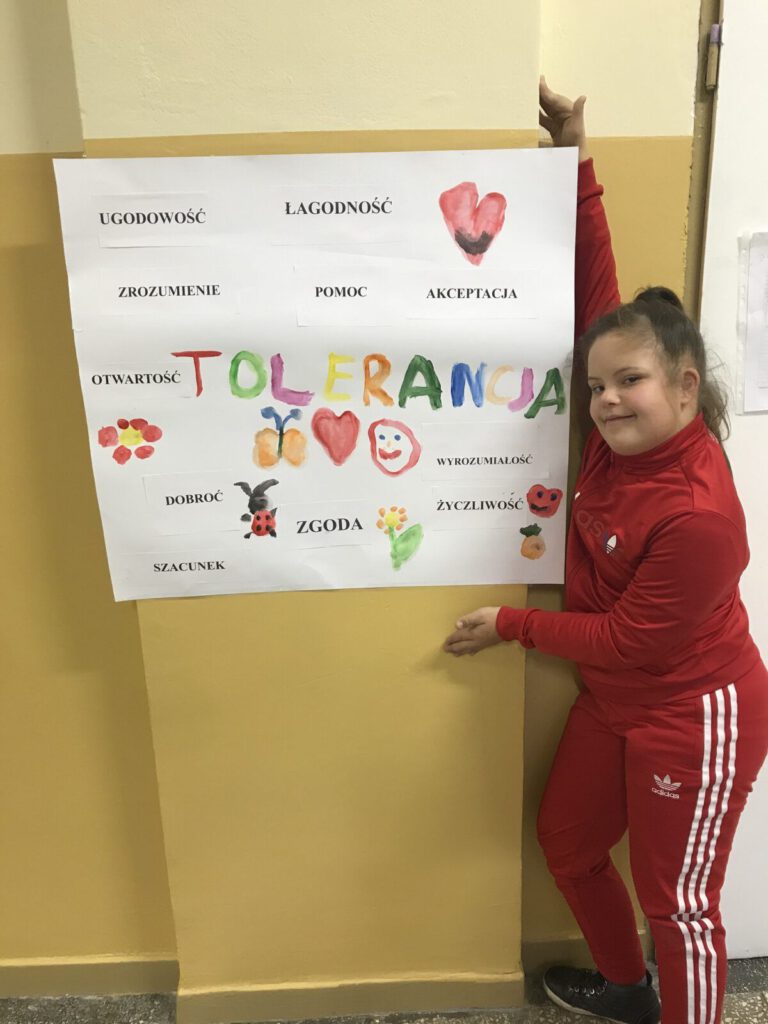 Międzynarodowy Dzień Tolerancji - plakat wykonany przez uczniów SP21 prezentuje jedna z uczennic