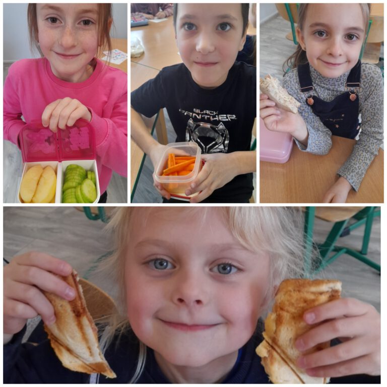Uśmiechnięte dzieci pokazują swoje śniadaniówki - zdrowe posiłki wykonane z owoców, warzyw i pieczywa