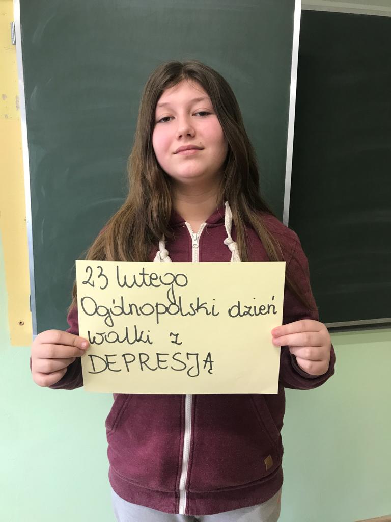 uczennica trzyma w rękach kartkę z napisem 23 lutego Ogólnopolski dzień walki z depresją