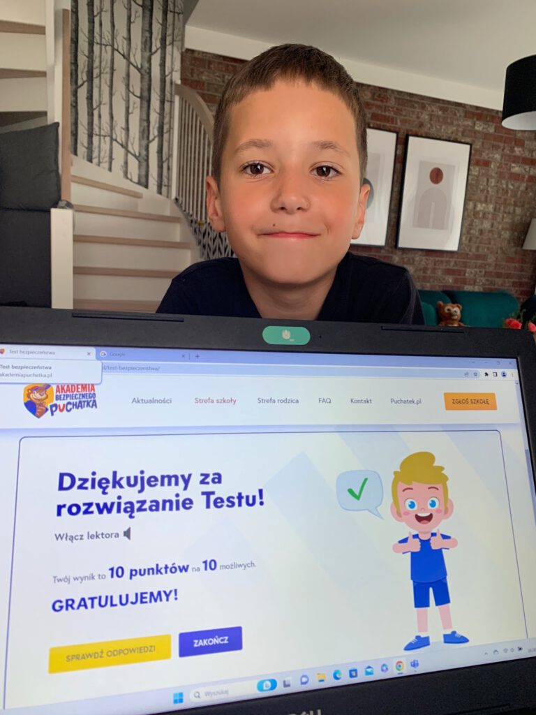 uśmiechnięty chłopiec rozwiązuje test w komputerze
