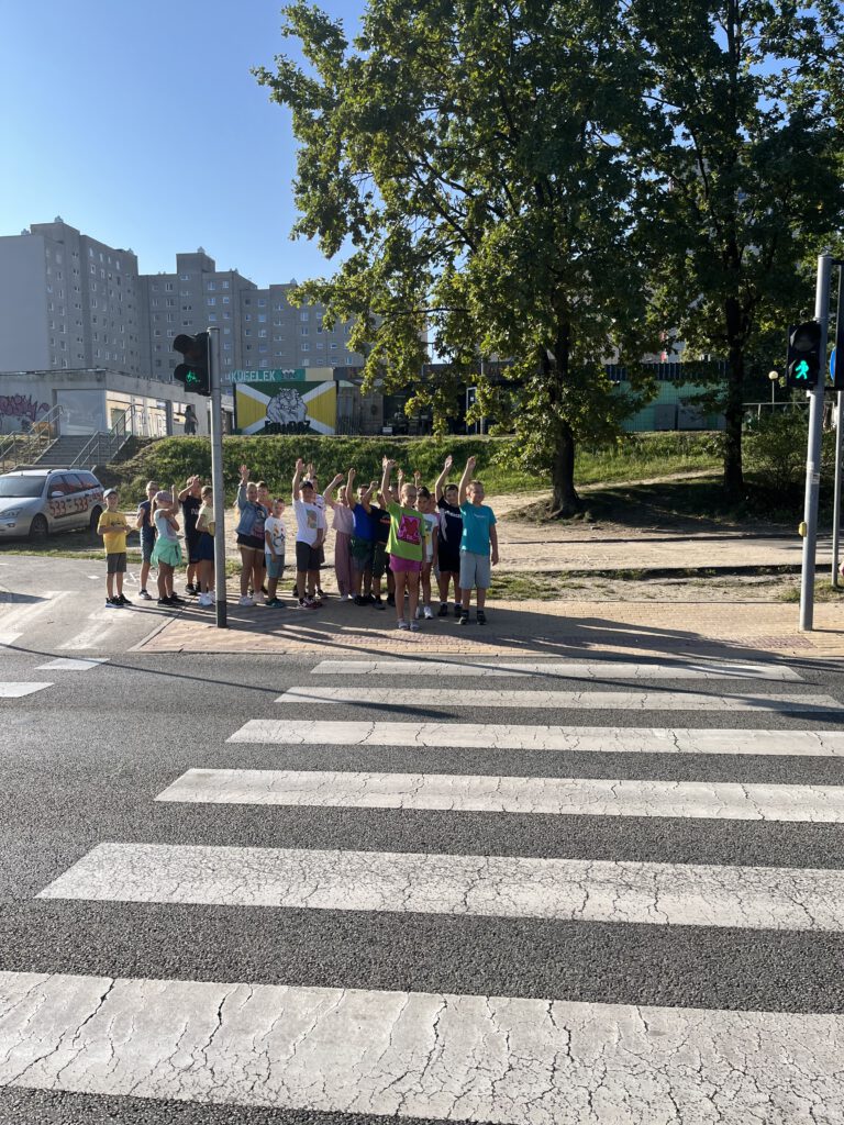 grupa uczniów stoi przed przejściem dla pieszych