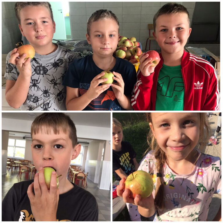 uczniowie trzymają w rękach jabłka