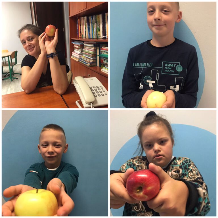 uczniowie i nauczycielka pozują do zdjęć trzymając jabłka
