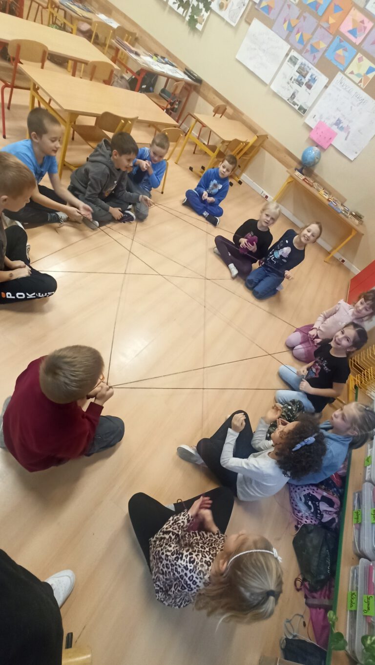 dzieci siedzą na podłodze w klasie i tworzą drzewko tolerancji