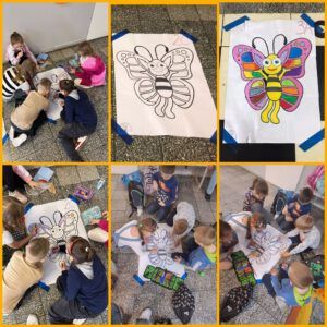 dzieci kolorują duże plansze z motylami