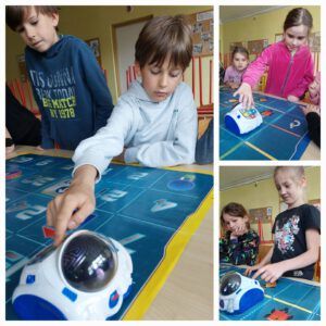 dzieci bawią się i uczą przy pomocy robota edukacyjnego