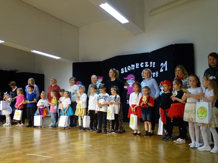 Dzieci i nauczyciele na scenie, odbierają nagrody