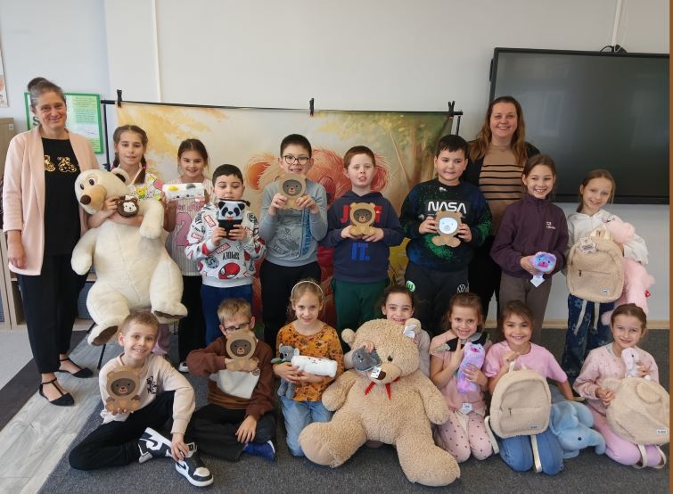 grupa dzieci i nauczycieli, dzieci trzymają wielkie pluszowe misie