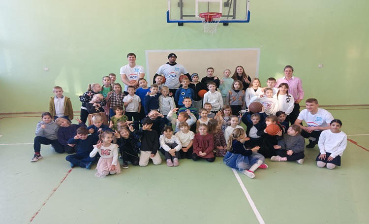 uczniowie i koszykarze w grupie w sali gimnastycnzej